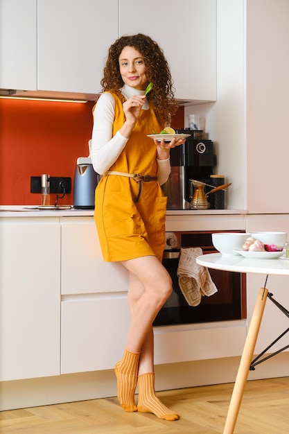 Cute woman holds spinach leaf in hand