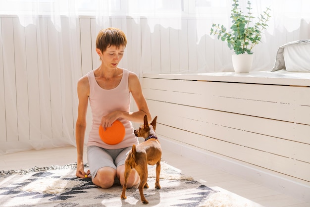 Cute woman practicing yoga with dog breed pygmy pinscher enjoy and relax