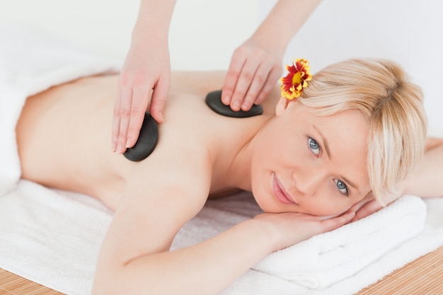 Photo cute woman receiving a massage with hot stones