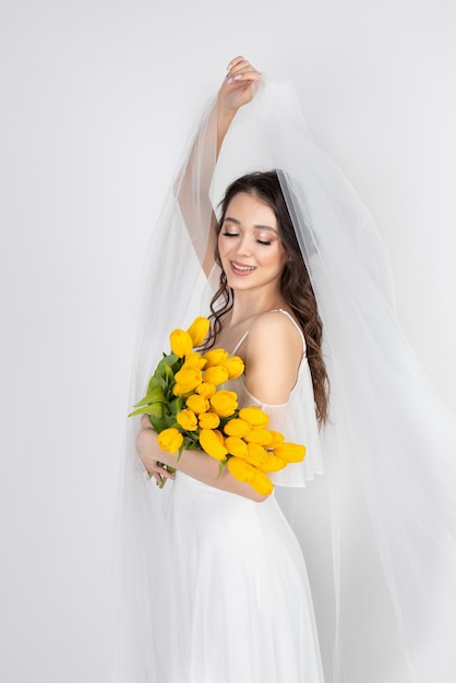 Cute woman with bouquet of yellow tulips