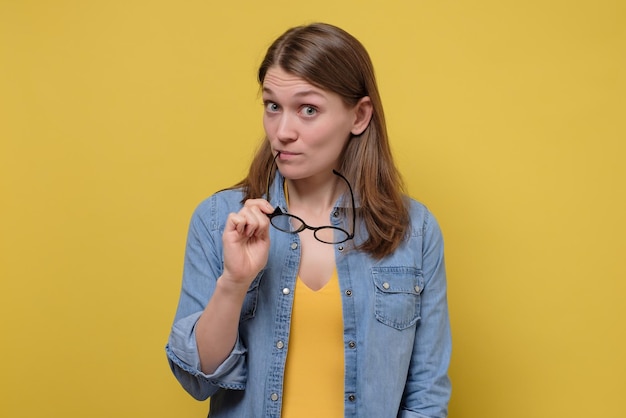 Cute woman with glasses gazing with interest and curiousity at camera