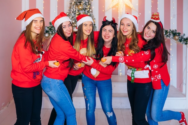 Cute women with red sweaters celebrating Christmas