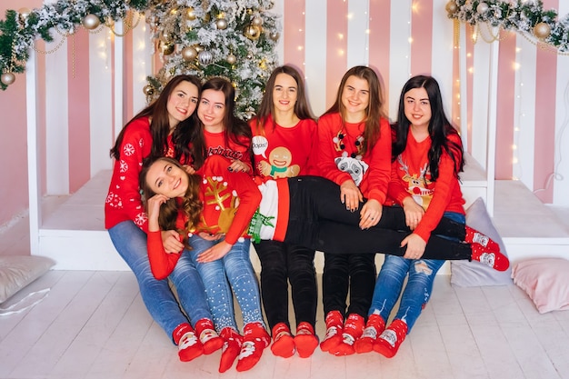 Cute women with red sweaters celebrating Christmas