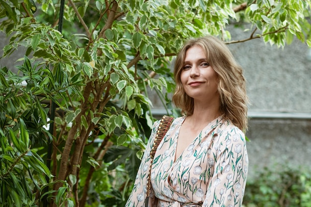 Cute young blonde woman in the greenhouse