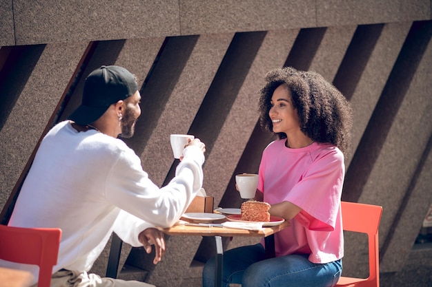 Cute young couple having coffee in the street cafe