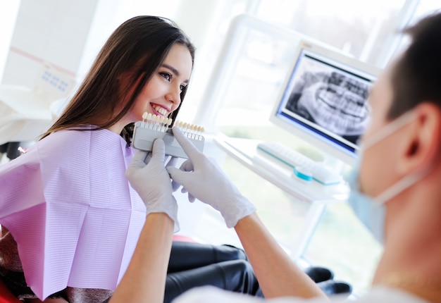 Cute young girl in dentist's chair.the selection of the color of teeth