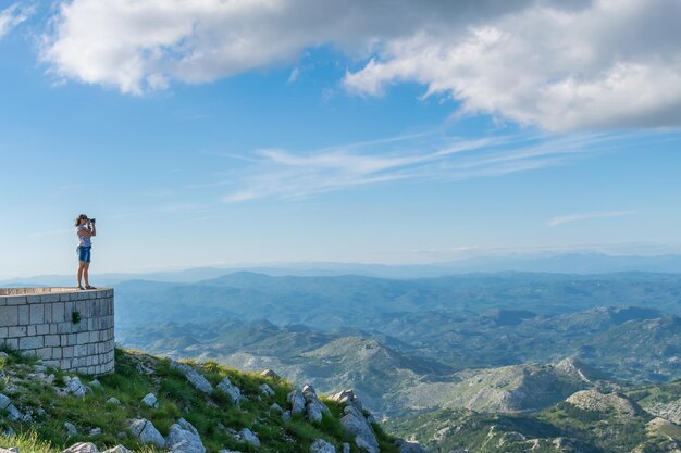 Cute young girl photographer admiring scenery from the viewpoint