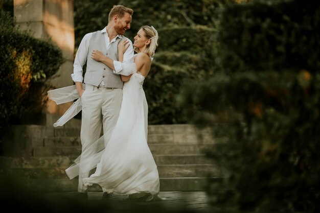 Cute young newlywed couple standing in the park