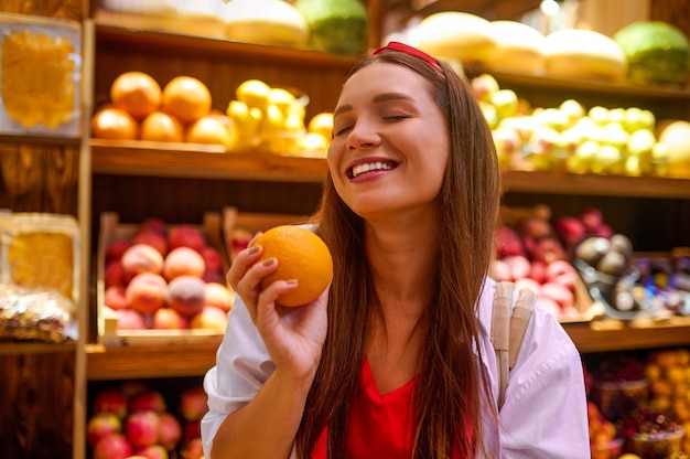 A cute young woman in a fruits store