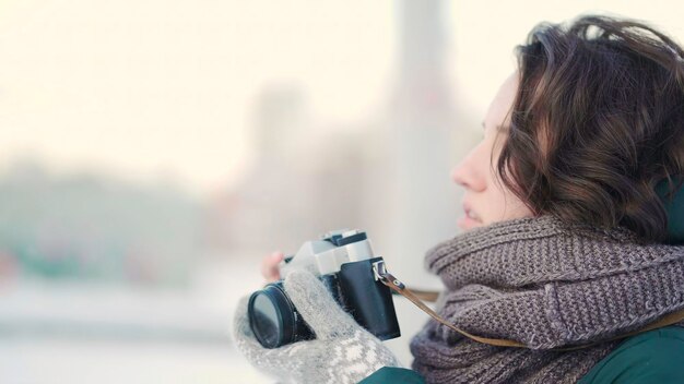 Photo cute young woman taking picture beautiful young woman taking pictures in the city in winter