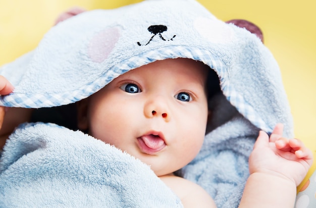 Cutest baby child after bath with towel on head. Adorable smiling baby boy!