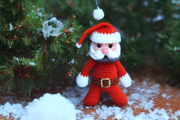 Cutest Santa claus in forest with snow. Crochet style with wool