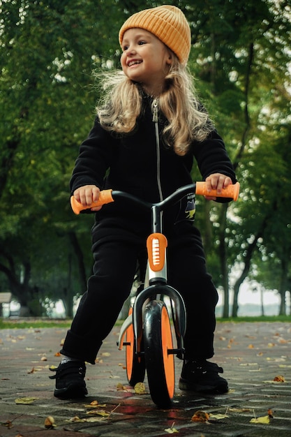 Cutie little girl rides on bicycle at the park