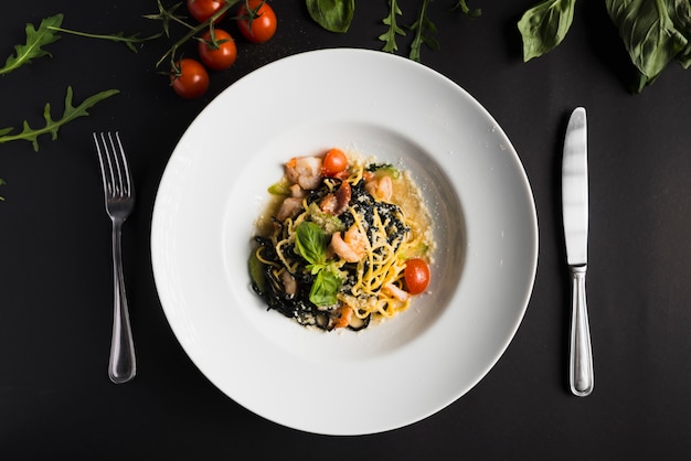 Cutlery near plate with pasta