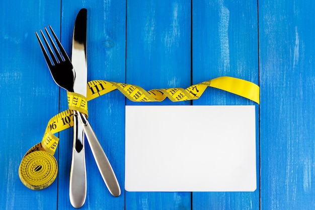 Cutlery with a meter tape and a blank piece of paper