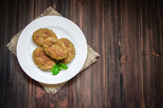 Cutlets in a plate on a wooden background