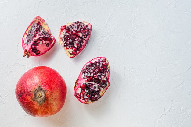 Cuts of pomegranate and whole garnet over white