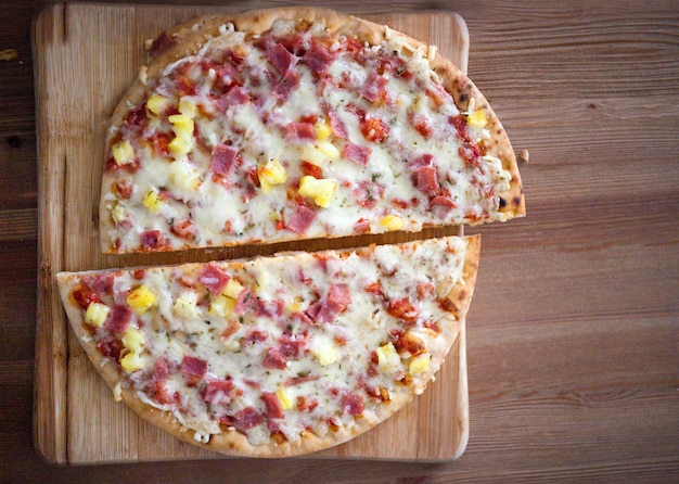 cutted homemade pizza slices delicious italian pizza served on wooden table top view