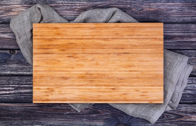 Cutting board on dark wood background top view