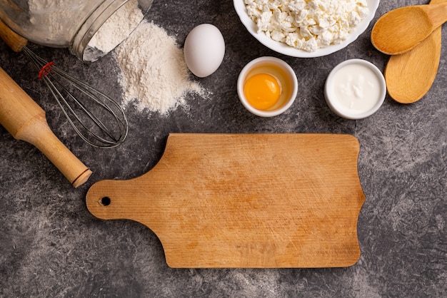 Cutting board with ingredients for making homemade pie on a stone background. Top view, copy space.