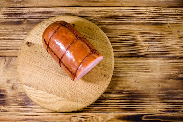 Cutting board with sausage on wooden table Top view