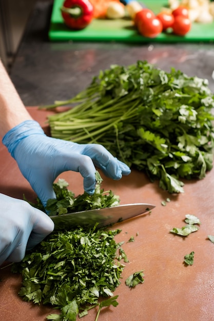 Cutting herbs for a salad. Green fresh parsley. Proper nutrition, vegan eating concept