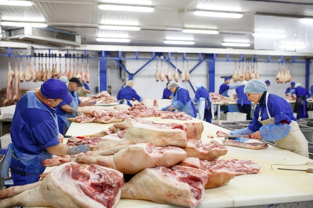 Cutting meat in slaughterhouse .