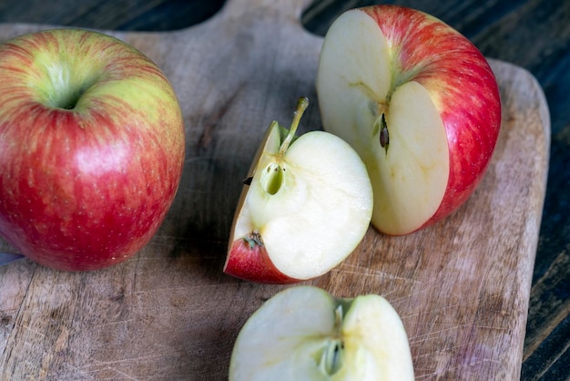 Cutting old board with pieces of red ripe apple