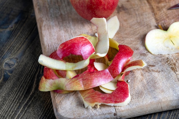 Cutting old board with pieces of red ripe apple