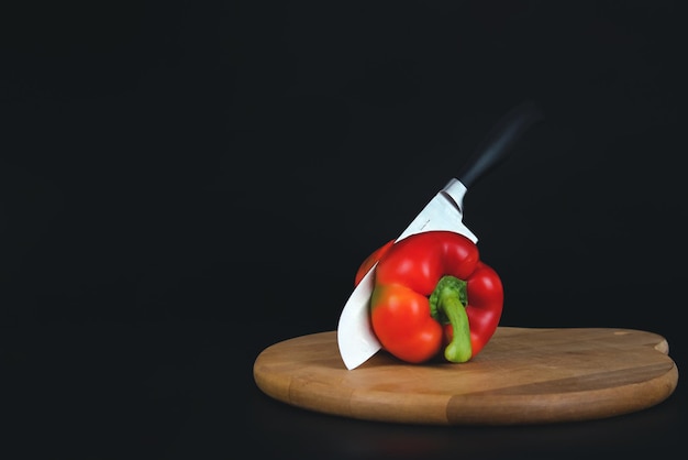 Cutting Sweet red pepper with a kitchen knife on the board