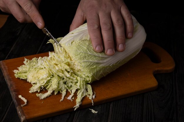 Cutting vegetables Male hands cutting cabbage on a cutting board