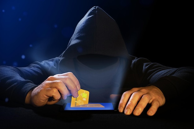 Cyber thief stealing a credit card from a cell phone Phishing alert Bank data theft