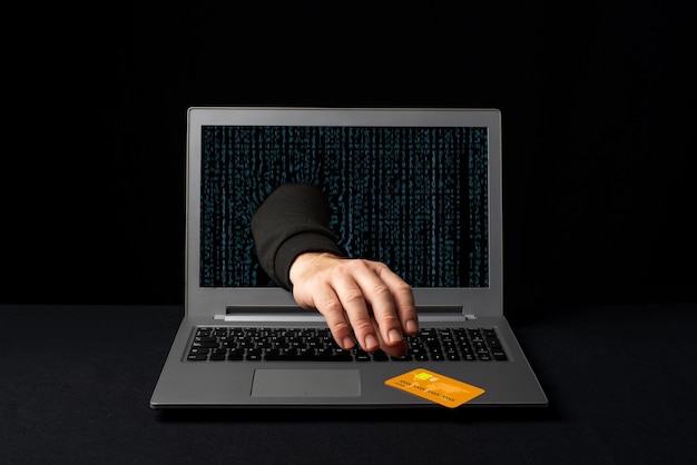 A cybercriminal reaching through a laptop to steal an online shopper's credit card Internet scams