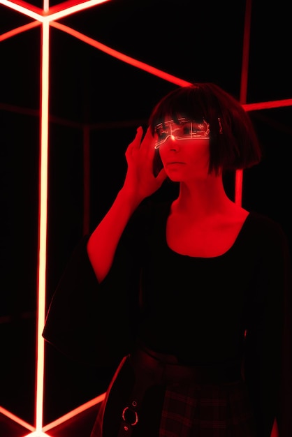 Cyberpunk and neon Girl in virtual reality glasses with short black hair Augmented reality game future technologies concept Neon light dark background