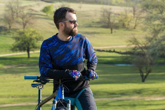 Cyclist on green meadows on a summer evening beautiful landscape