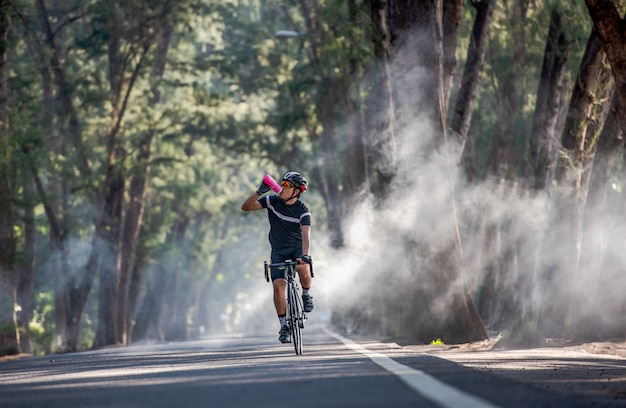 Cyclist is drinking water from the sport bottle