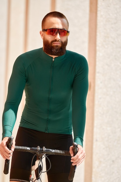 Cyclist man riding fixed gear sport bike in sunny day on a city