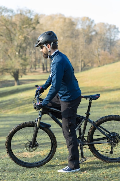 Cyclist in pants and fleece jacket on a modern carbon hardtail bike with an air suspension fork The guy on the top of the hill rides a bike