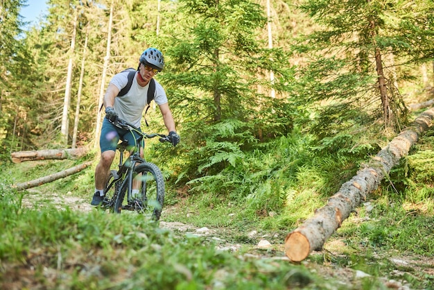 A cyclist rides a bike on extreme and dangerous forest roads Selective focus