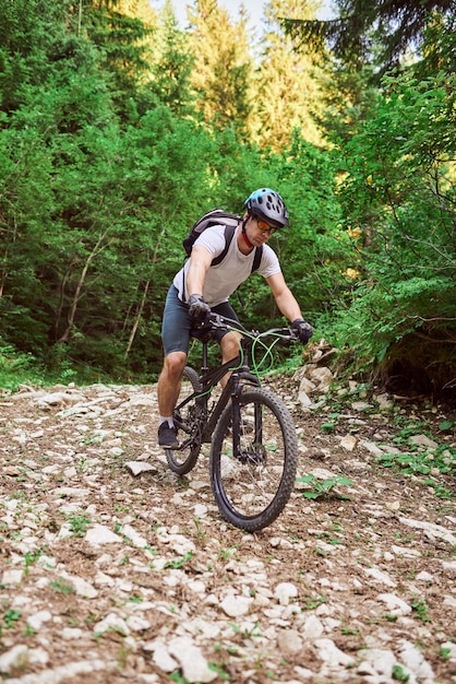 A cyclist rides a bike on extreme and dangerous forest roads Selective focus