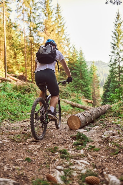 A cyclist rides a bike on extreme and dangerous forest roads Selective focus