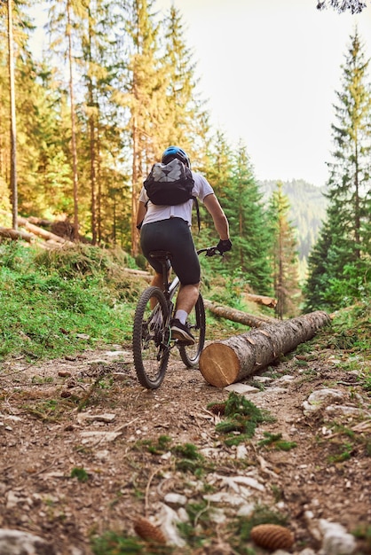 A cyclist rides a bike on extreme and dangerous forest roads Selective focus