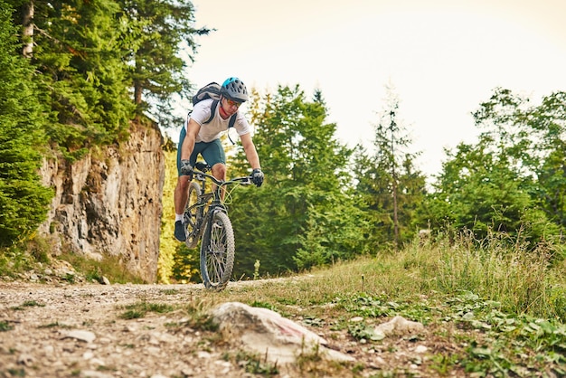 Cyclist Riding the Bike on the Trail in the Forest Man cycling on enduro trail track Sport fitness motivation and inspiration Extreme Sport Concept Selective focus