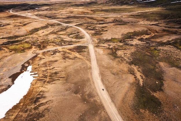 Cyclist riding on dirt road among the volcanic wilderness in Icelandic Highlands on summer at Iceland