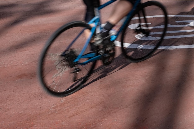 Cyclist riding road bicycle on a road pedaling preparing for the competition