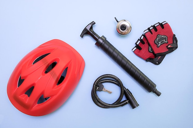 Cyclist's accessories on a blue background helmet pump lock with keys bell gloves