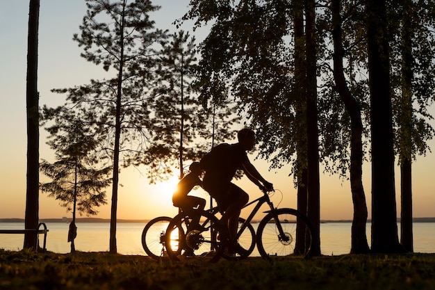 Cyclists in the forest at sunset Couple walking on bike in nature Active lifestyle recreation sport