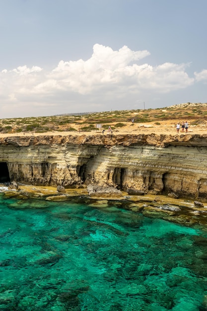 CYPRUS, AYA NAPA. Tourists stroll along the coast near the picturesque sea caves