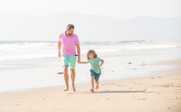 Dad and child having fun outdoors childhood and parenting smiling father and son running on summer beach family travel weekend and vacation fathers or family day daddy with kid boy on summer day