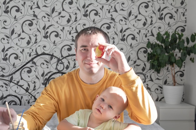 Dad and child paint eggs for Easter